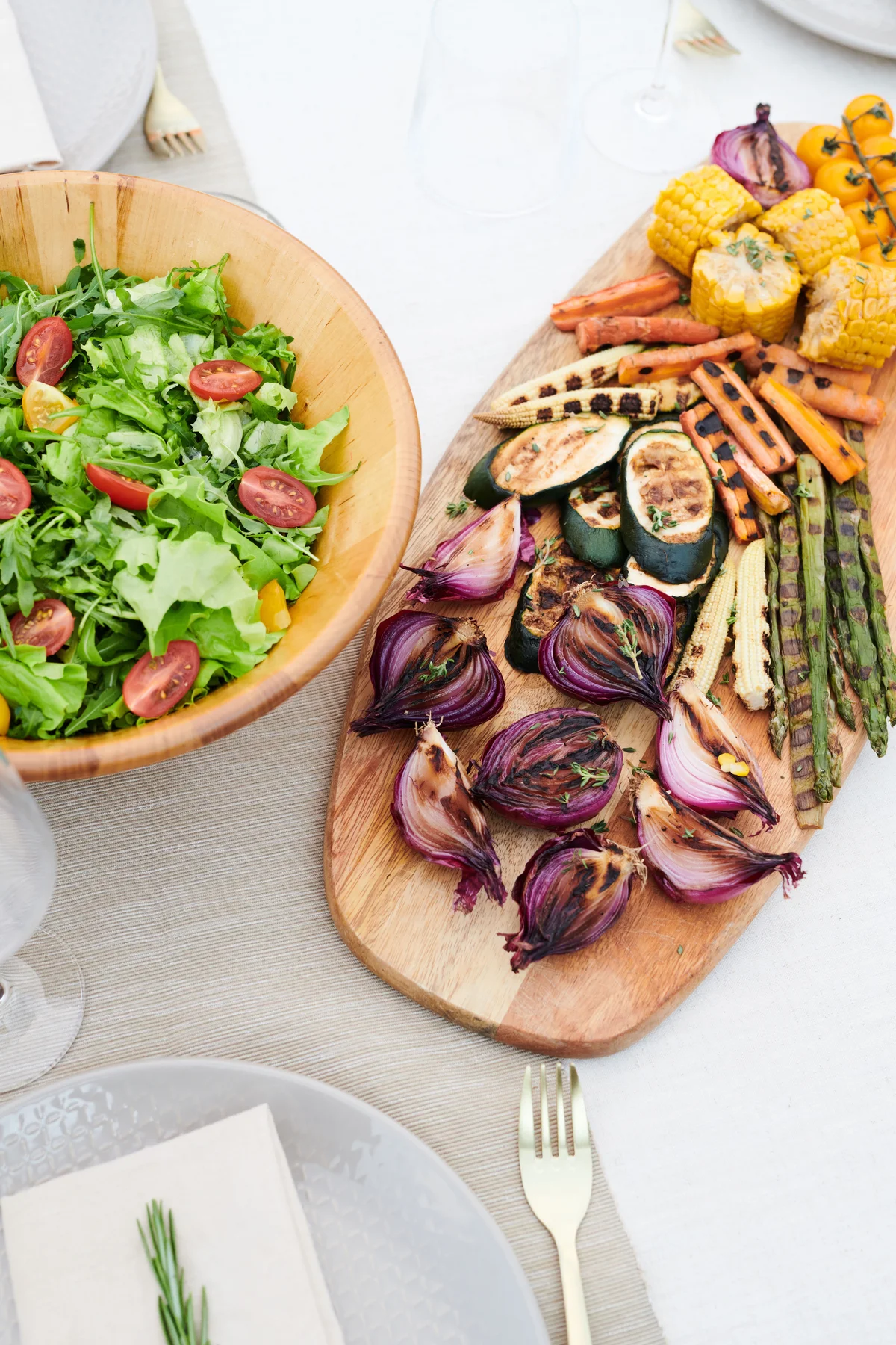 A table set with salad and seasonal grilled vegetables