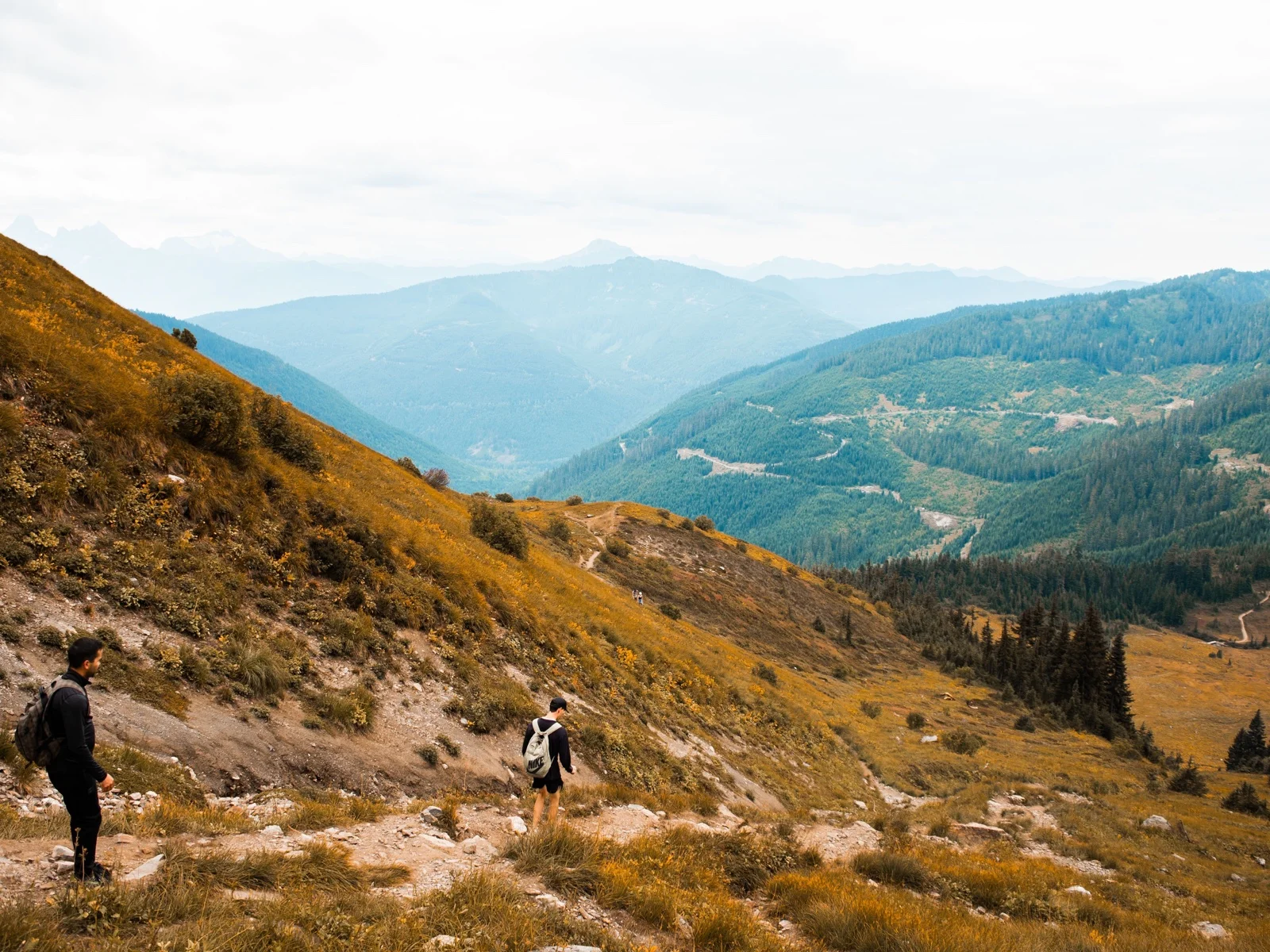 Hikers descending a mountain ridge trail